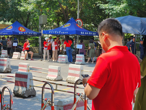 8日，學校官員和父母在北京科技大學高中面前穿著紅色衣服，在那裡舉行了中國大學入學考試Kaokao。通訊員李do -Sung。