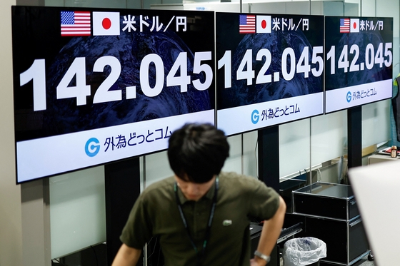 去る5日日本東京で外国為替取引会社の職員が米ドル対日本円為替レートを表示するモニターを過ぎている。 〈写真=ロイター〉