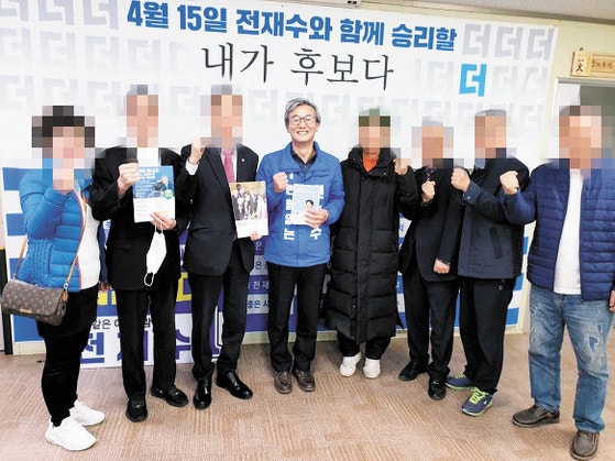 전재수 더불어민주당 의원이 21대 총선을 앞둔 2020년 3월 23일 통일교 계열의 (사)남북통일운동국민연합 관계자들을 만나는 자리에서 한학자 통일교 총재의 자서전을 들고 기념촬영하고 있다.〈사진=중앙일보 독자 제