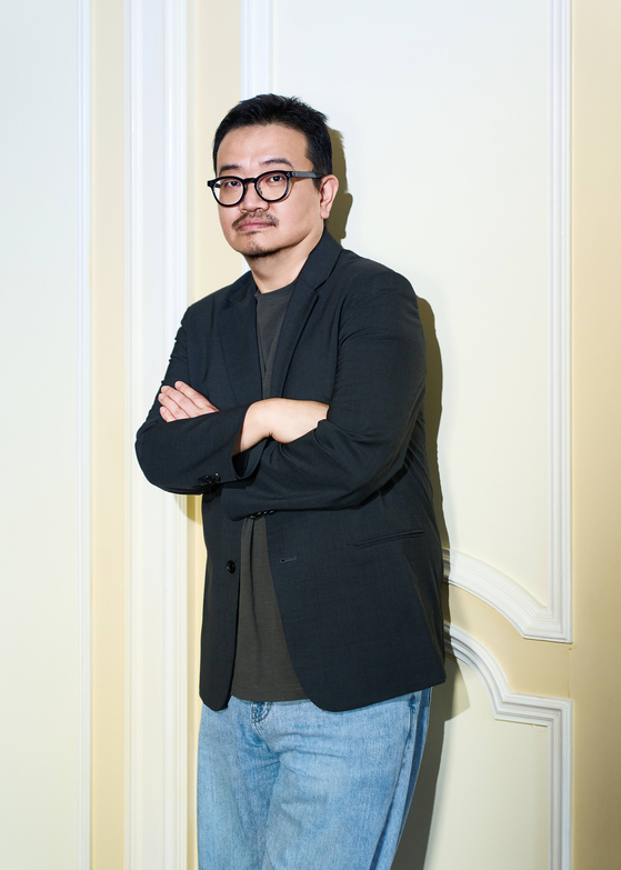 黒いジャケット姿で腕を組むヨン・サンホ監督