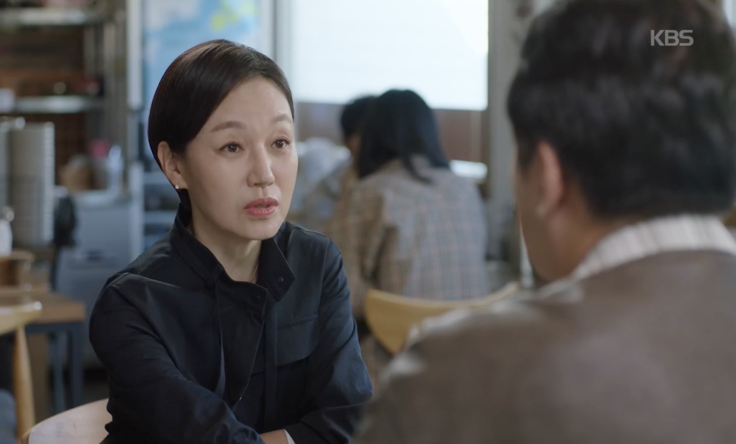 KBSドラマ『愛が来る』で食堂の席に座り、向かいの人物に話しかけるチン・ギョン