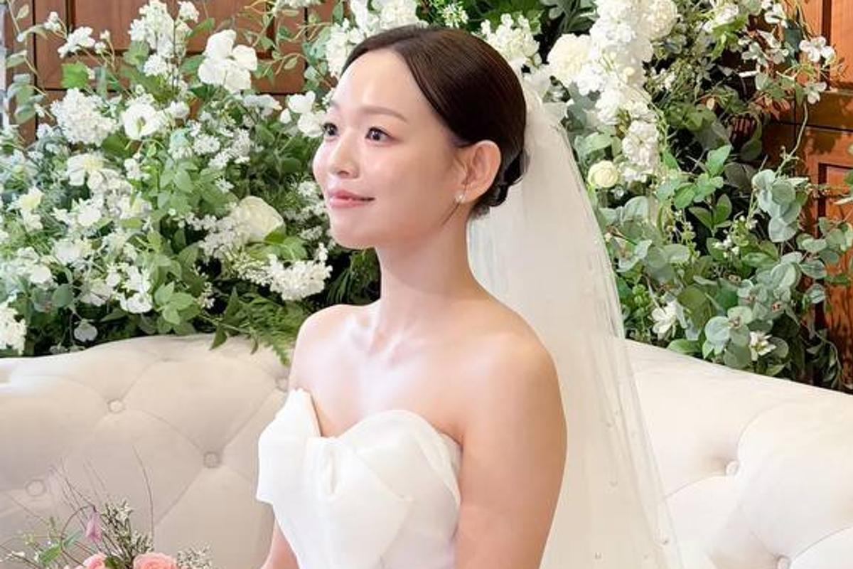 ウェディングドレス姿で白いソファに座るミュージカル俳優イ・ヒュ