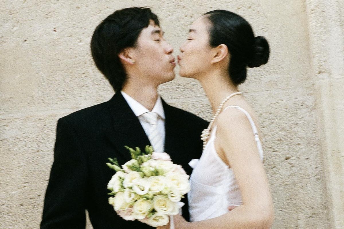 ウェディングドレス姿のジン・ユーと黒いスーツ姿のリン・ズーハオがキスをする