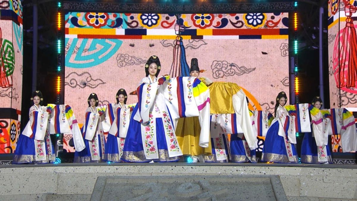 伝統衣装をまとった出演者たちが屋外ステージで舞う様子