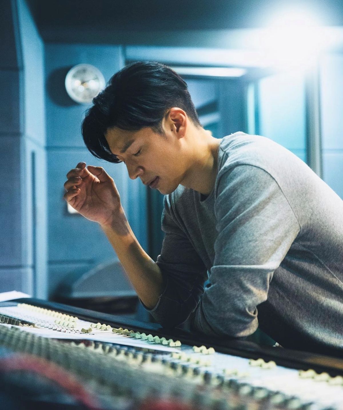 音楽制作卓の前で作業する歌手Tim