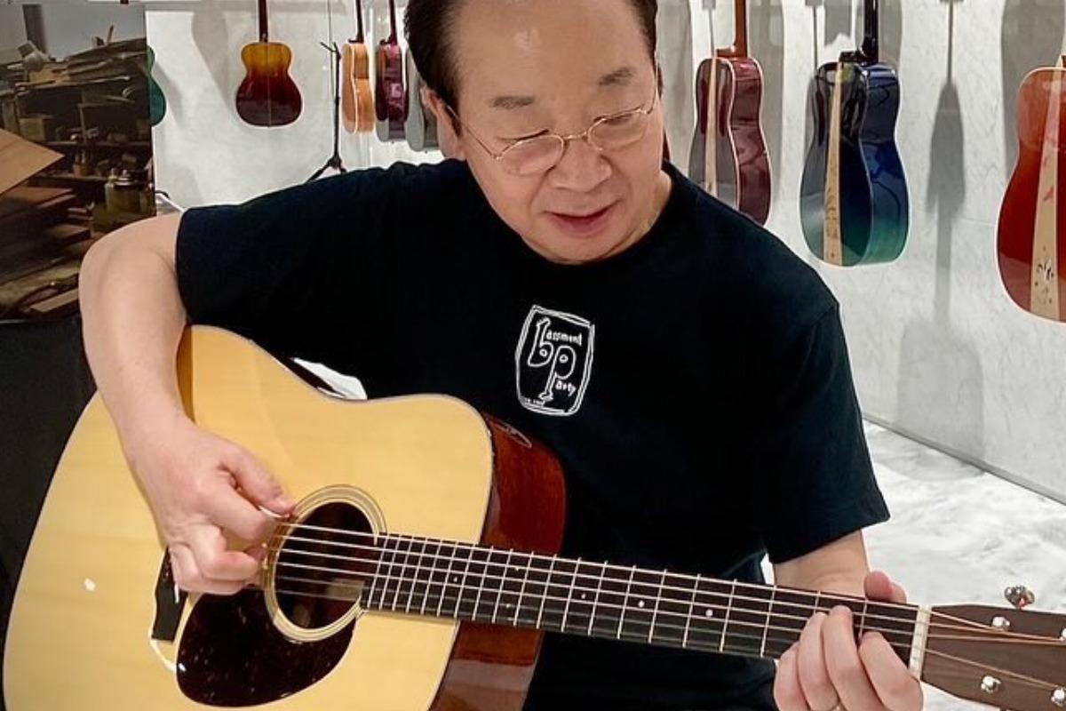 ギターを手に演奏する中村梅雀