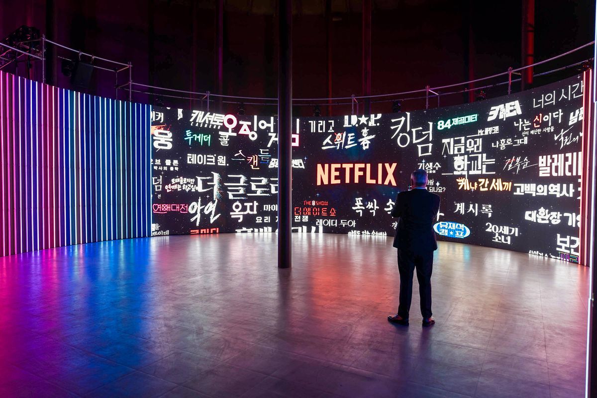 Netflix作品のタイトルが並ぶ展示壁を後ろ姿の人物が見ている