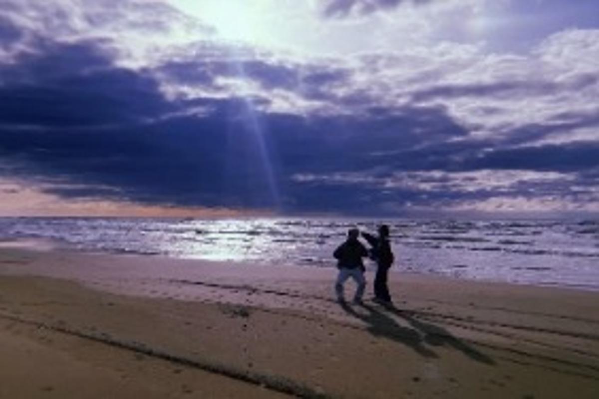 海辺で並ぶ二人の姿を捉えた写真