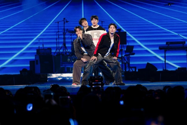青い照明のステージでパフォーマンスするDAY6のメンバー