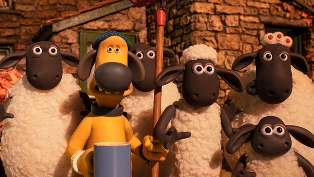 映画『ひつじのショーン：恐怖の毛むくじゃら怪物』のスチル。ショーンと仲間の羊たちが小屋の前に集まっている。
