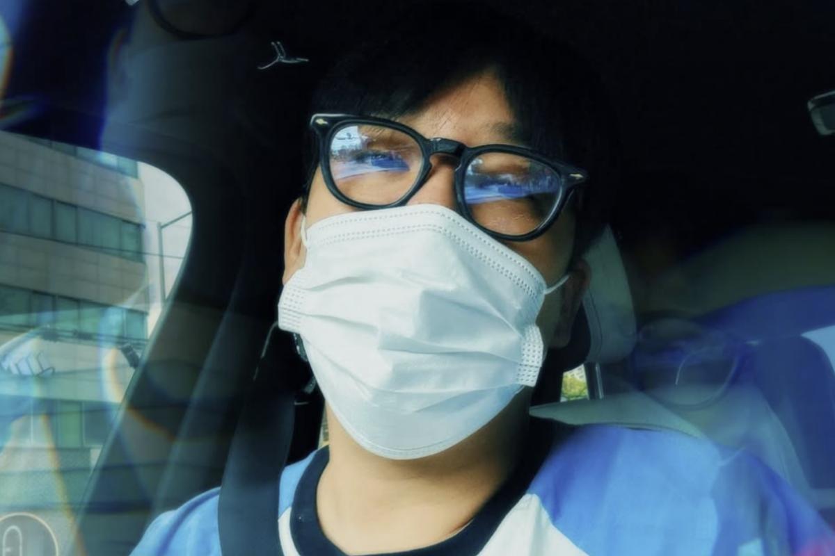車内で眼鏡とマスクを着けたMCモンの自撮り写真