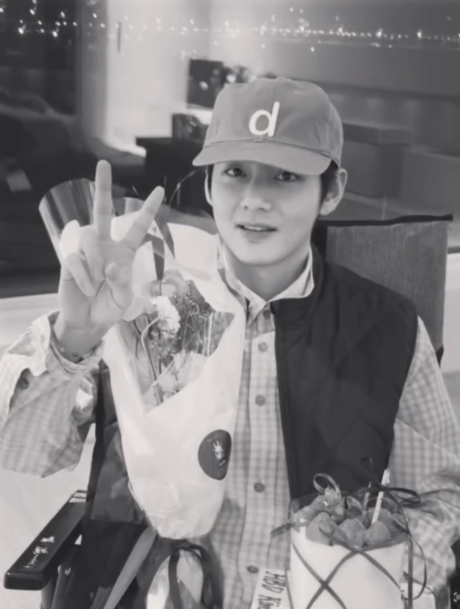 V يمسك كيكة الفراولة محاطا بأعضاء الفريق