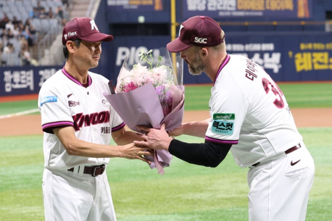 키움 데이비슨(오른쪽)이 22일 서울 고척스카이돔에서 열린 2026 KBO리그 두산전에 앞서 통산 100홈런 기념 시상식에서 설종진 감독으로부터 꽃다발을 건네받고 있다. 사진 | 키움 히어로즈