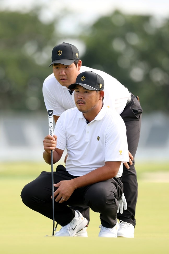 김시우(오른쪽)와 김주형이 25일(한국시간) 미국 시카고 메데나CC에서 열린 프레지던츠컵 첫날 경기에서 신중한 표정으로 그린을 읽고 있다. 사진 | 게티이미자·PGA투어