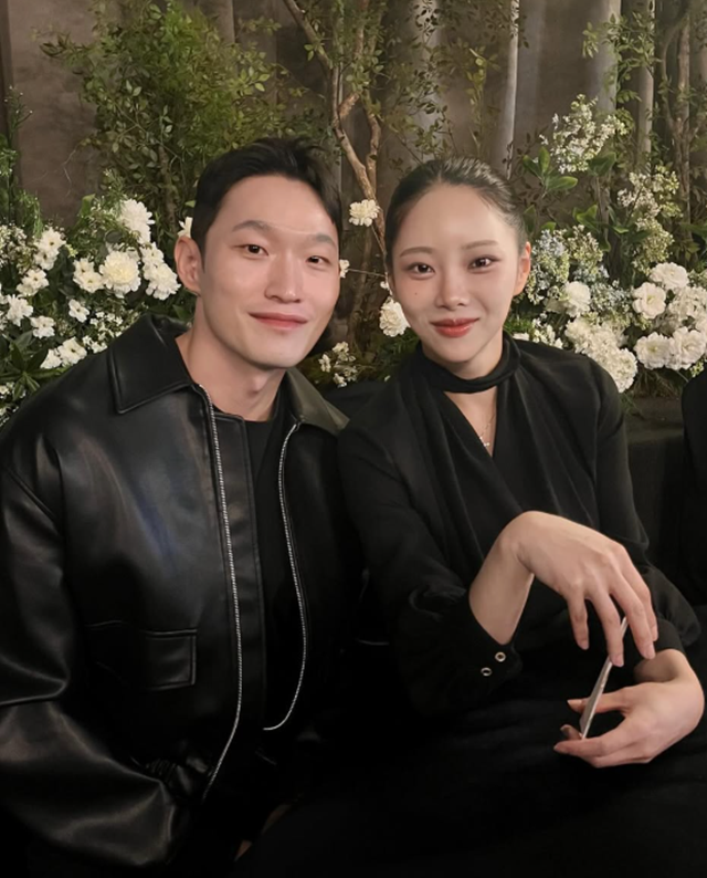 結婚式を前に、花の飾られた壁の前で並ぶキム・スルギとユ・ヒョンチョル