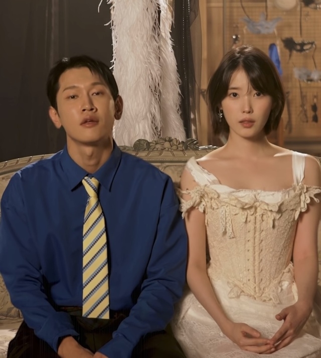 ミュージックビデオの場面で並んで座るCrushとIU