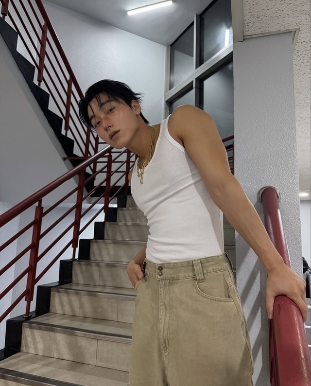 白いタンクトップ姿のATEEZサンが階段でポーズを取る