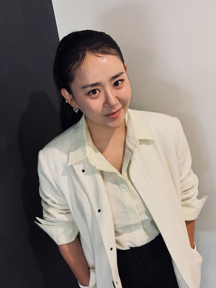アイボリーのシャツ姿で笑顔を見せるムン・グニョン