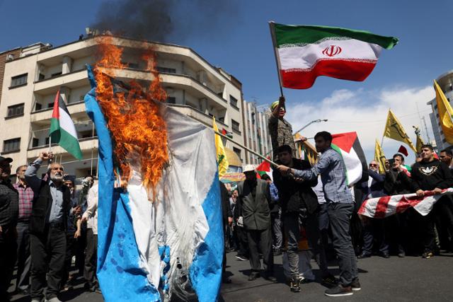 이란 시위대가 지난 5일 수도 테헤란에서 이스라엘 국기를 불태우며 지난 1일 이스라엘의 시리아 주재 이란 영사관 공격에 대해 항의하고 있다. 로이터 연합뉴스