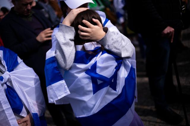 독일 베를린에서 열린 이스라엘 연대 시위에 참가한 한 여성이 14일 아이를 끌어안고 있다. 베를린=AP 연합뉴스
