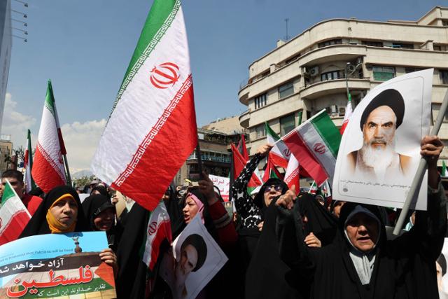 이란인들이 19일 수도 테헤란에서 금요일 정오 기도를 마친 뒤, 이란 국기를 흔들며 반(反)이스라엘 시위를 하고 있다. 테헤란=AFP 연합뉴스