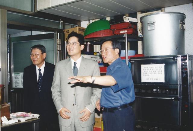 이재용(가운데) 삼성전자 회장(당시 상무)이 2003년 6월 서울 영등포 요셉의원을 방문한 자리에서 고 선우경식(오른쪽) 원장의 안내를 받아 목욕실·세탁실·이발실을 둘러보고 있다. 위즈덤하우스 제공