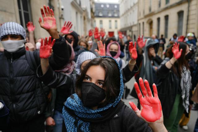 26일 프랑스 명문 정치대학 시앙스포에서 손바닥에 빨간 칠을 한 학생 수십 명이 친팔레스타인 시위를 벌이고 있다. 파리=AFP 연합뉴스