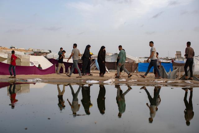 팔레스타인 가자지구 피란민들이 지난 26일 최남단 도시 라파에서 난민 캠프 인근을 배회하고 있다. 라파=EPA 연합뉴스