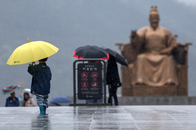 어린이날이었던 5일 서울 종로구 광화문광장에서 우산을 든 아이가 쏟아지는 빗속에 걸음을 옮기고 있다. 이날 전국에서 열릴 예정이었던 어린이날 행사는 비 때문에 취소되거나 축소 운영됐다. 뉴스1