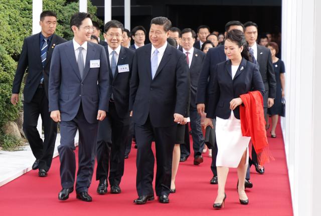 2014년 7월 서울 신라호텔에서 열린 한중경제협력포럼에 참석한 시진핑(가운데) 중국 국가주석과 부인 펑리위안(오른쪽) 여사가 이재용 삼성전자 부회장과 함께 삼성전자 전시관을 참관하기 위해 영빈관으로 이동하고 있다.