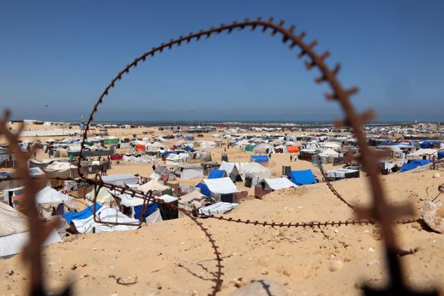 9일 철조망 너머로 가자지구 남부 라파의 팔레스타인 난민 캠프가 보인다. 라파=AFP 연합뉴스