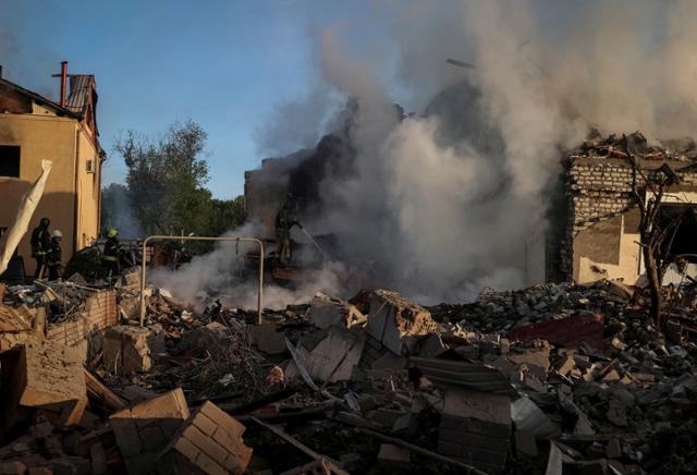 10일 러시아군의 공격을 받은 우크라이나 동북부 하르키우의 건물 잔해에서 연기가 피어오르고 있다. 하르키우=로이터 연합뉴스