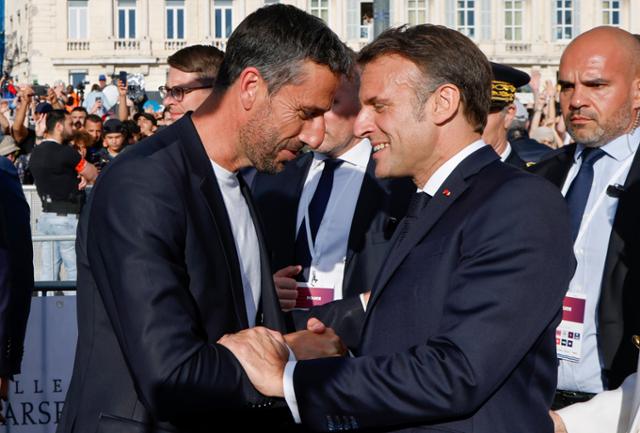 에마뉘엘 마크롱(오른쪽) 프랑스 대통령과 토니 에스탕게 파리 2024 올림픽·패럴림픽 조직위원장이 8일(현지시간) 프랑스 남부 마르세유에서 열린 2024 파리올림픽 성화 도착 기념식에서 악수하고 있다. 마르세유=AP