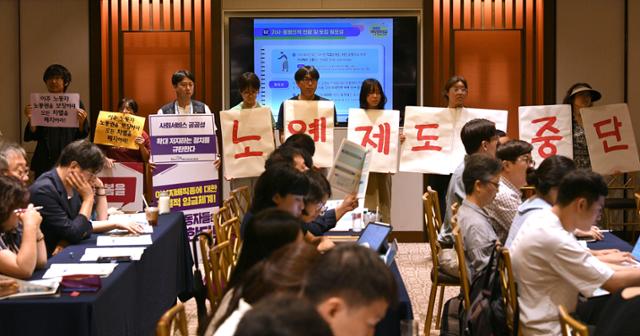 한국여성노동자회 등 시민·사회단체 회원들이 지난해 7월 31일 서울 중구 로얄호텔에서 고용노동부 주최로 열린 외국인 가사근로자 도입 시범 사업 관련 공청회를 찾아 '노예제도 중단'이라고 적힌 피켓을 들고 시위하고 있