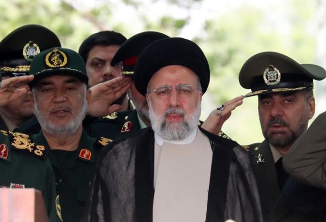 에브라힘 라이시(가운데) 이란 대통령이 지난달 17일 이란 테헤란에 있는 한 군사 기지에서 군인들의 경례를 받고 있다. 최고지도자 아야톨라 알리 하메네이의 뒤를 잇는 이란의 2인자였던 라이시 대통령은 19일 헬기 추
