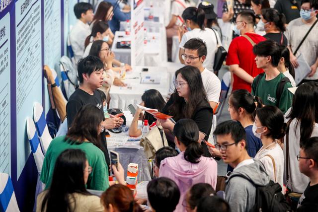 지난해 8월 15일 중국 후베이성 우한에서 열린 취업박람회에 참석한 대학 졸업생들이 취업에 관한 설명을 듣고 있다. 우한=AFP 연합뉴스