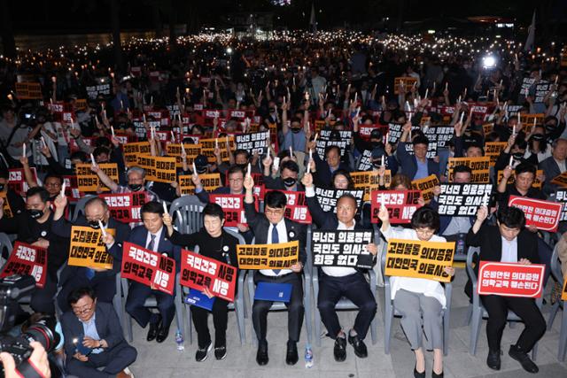 30일 오후 서울 덕수궁 대한문 앞에서 의사협회 주최로 열린 대한민국정부 한국 의료 사망선고 촛불집회에서 촛불을 든 참석자들이 묵념을 하고 있다. 뉴스1