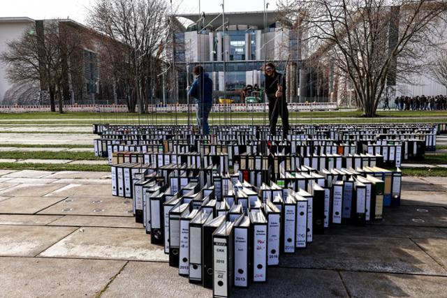 지난 2월 독일 베를린 총리실 앞에 연방 정부의 수공예 정책에 반대하는 시위대가 독일 관료주의를 상징하는 서류 폴더를 늘어놨다. 베를린=EPA 연합뉴스