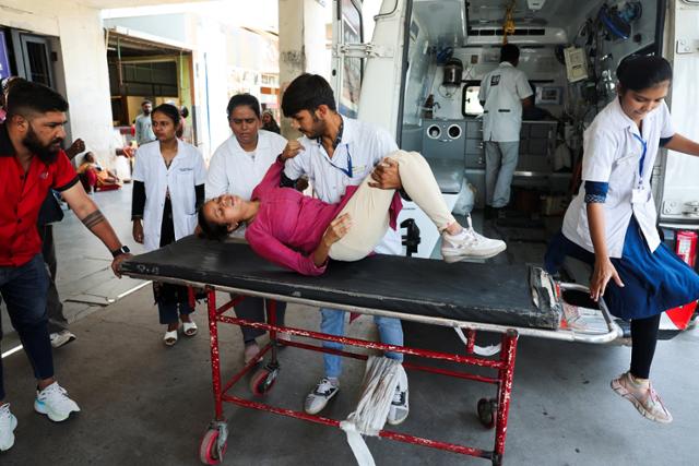지난달 24일 인도 아메다바드에서 의료진이 무더위로 쓰러진 시민을 병원으로 이송하고 있다. 아메다바드=로이터 연합뉴스