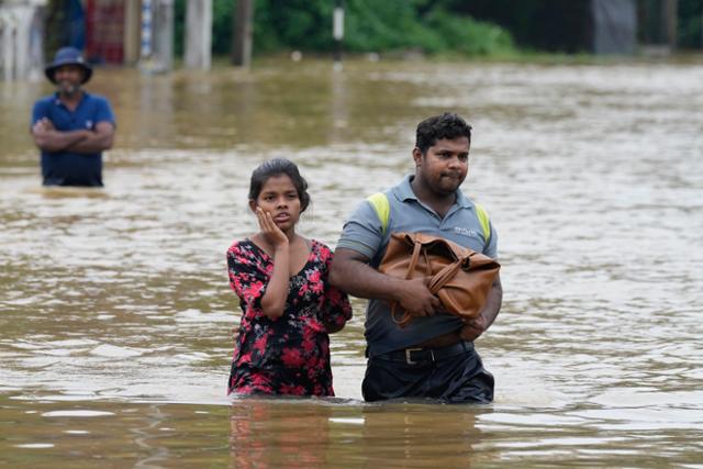 스리랑카 수도 콜롬보에 폭우가 내린 3일 시민들이 물을 헤치며 걸어가고 있다. 콜롬보=AP 연합뉴스
