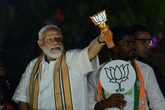 나렌드라 모디 인도 총리가 지난 4월 9일 인도 첸나이에서 열린 선거 운동 중 본인이 이끄는 인도국민당(BJP)을 상징하는 연꽃 조형물을 들고 지지자들에게 인사하고 있다. 첸나이=AP 뉴시스