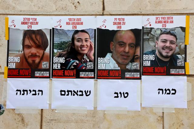 이스라엘 한 거리에 붙은 포스터에 8일 팔레스타인 무장 정파 하마스로부터 구출된 이스라엘 인질 4명의 초상화와 '이제 집으로'라는 문구가 인쇄돼 있다. AFP 연합뉴스