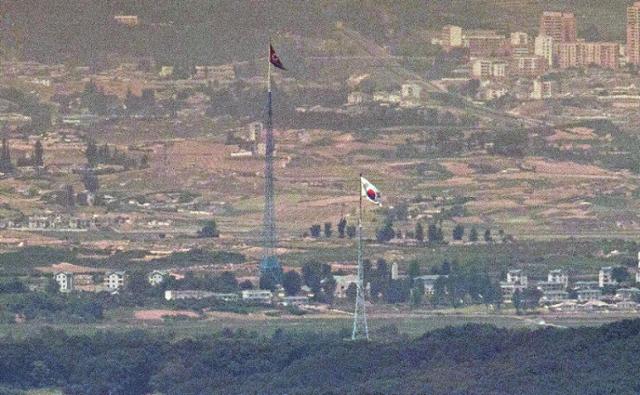 북한의 오물풍선 등의 도발로 9.19 군사합의 효력 정지 안건이 의결되는 등 남북 긴장관계가 고조되고 있는 6일 파주 접경지역에서 바라본 비무장지대(DMZ) 북한 기정동 마을의 인공기와 남한 대성동 마을의 태극기가 