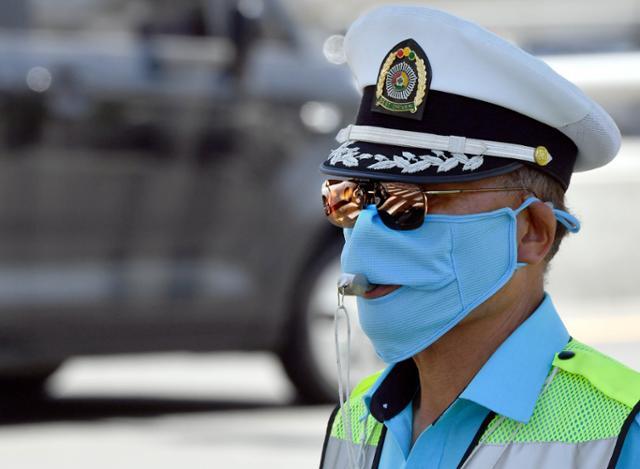 서울 중구 서울역 부근에서 마스크와 선글라스로 얼굴을 완전히 가린 채 교통 정리를 하고 있는 모범운전자. 한국일보 자료사진