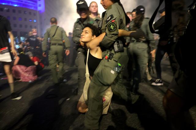 15일 이스라엘 텔아비브의 키리야 군 본부 밖에서 팔레스타인 무장 정파 하마스에 억류된 인질 석방을 촉구하는 집회가 열린 가운데, 경찰이 집회에 참가한 시민들을 연행하고 있다. 텔아비브=EPA 연합뉴스