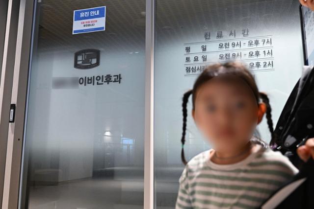 의료계 집단 휴진이 시작된 18일 한 어머니와 아이가 서울 중구의 한 병원 입구에 휴진 안내문이 붙어 있자 발걸음을 돌리고 있다. 정다빈 기자