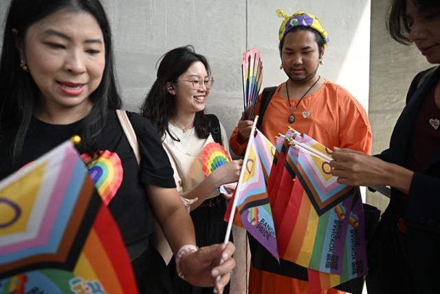 태국 상원이 동성 결혼 합법화 표결을 진행 중인 18일 방콕에서 성소수자 커뮤니티 회원들이 무지개 깃발을 들고 결과를 기다리고 있다. 방콕=AFP 연합뉴스