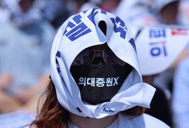 18일 서울 영등포구 여의대로에서 열린 전국 의사 총궐기대회에서 한 참가자가 현수막을 머리에 감고 있다. 연합뉴스