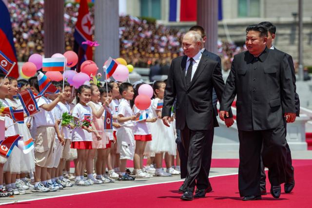 김정은(오른쪽) 북한 국무위원장과 블라디미르 푸틴 러시아 대통령이 평양 김일성 광장에서 평양 주민들의 환영을 받으며 걷고 있다. 평양=AP 뉴시스