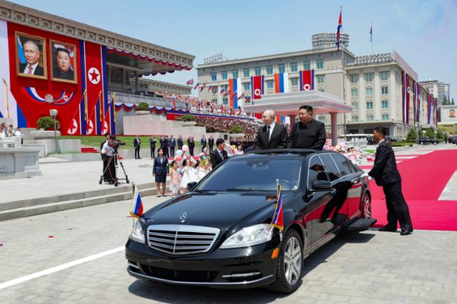 블라디미르 푸틴(왼쪽) 러시아 대통령과 김정은 북한 국무위원장이 독일 메르세데스-벤츠 차량을 타고 19일 북한 평양 김일성 광장에서 열린 공식 환영식에서 인사하고 있다. AP 연합뉴스